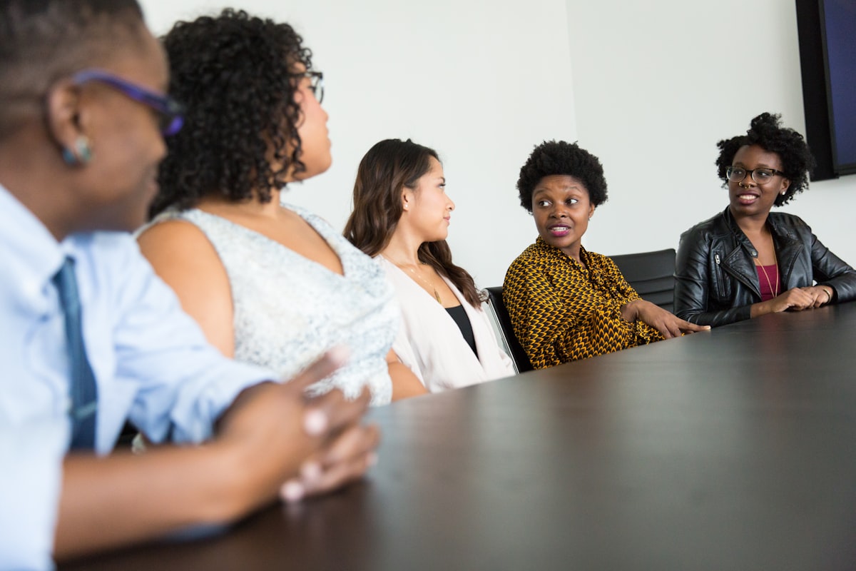 Colleagues share a conversation around a table.